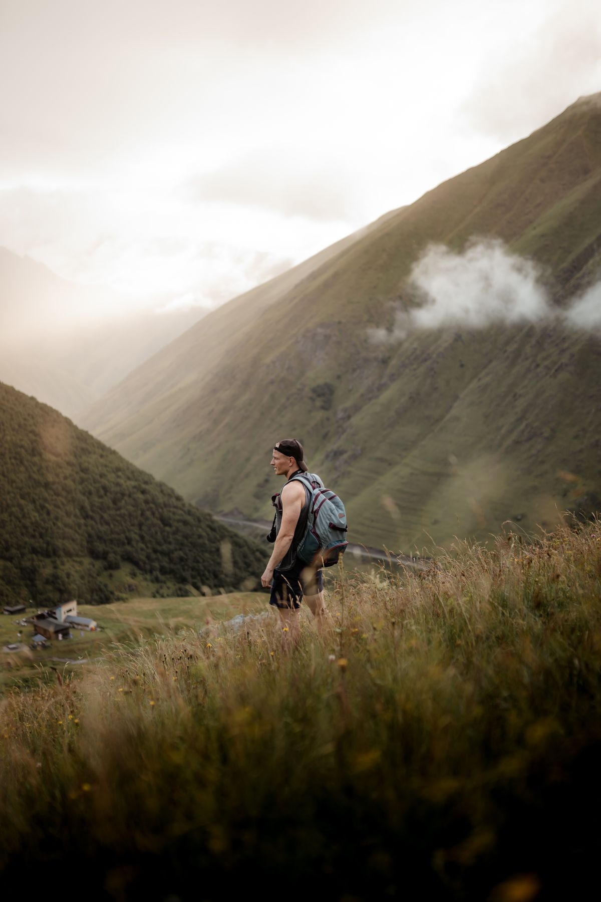 Hiker with a backpack on a trail in the Caucasus mountains, Georgia