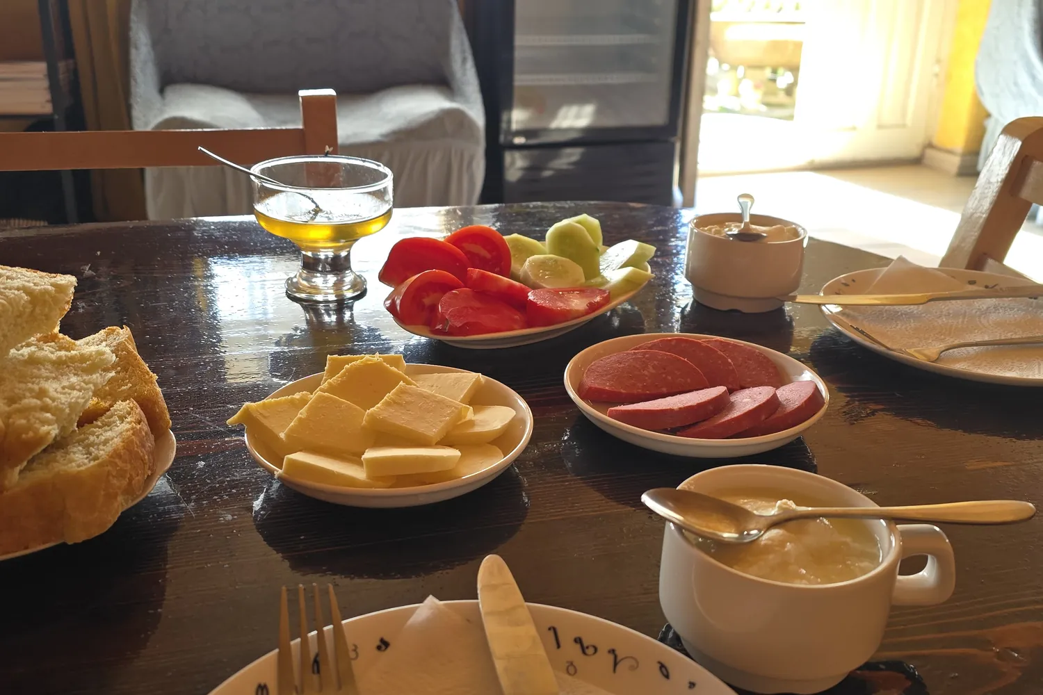 Breakfast laid on a wooden table in a family guesthouse in Svaneti, Georgia