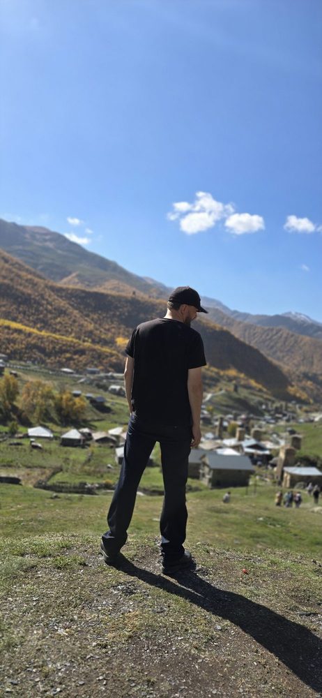Walker looking out over autumn mountains in Svaneti on the big hiking day toward Mount Ushba
