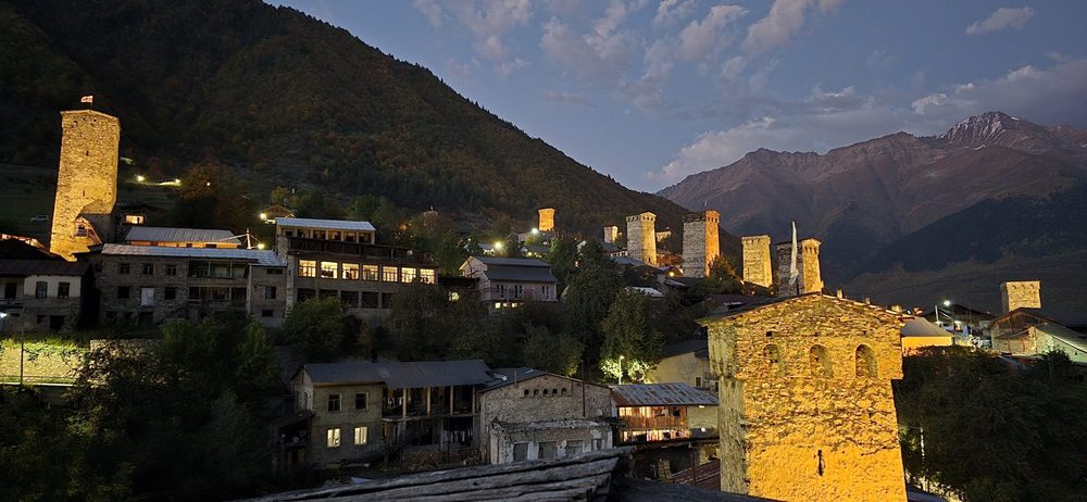 Medieval Svan defensive towers below a snow-capped Caucasus peak in Upper Svaneti near Ushguli