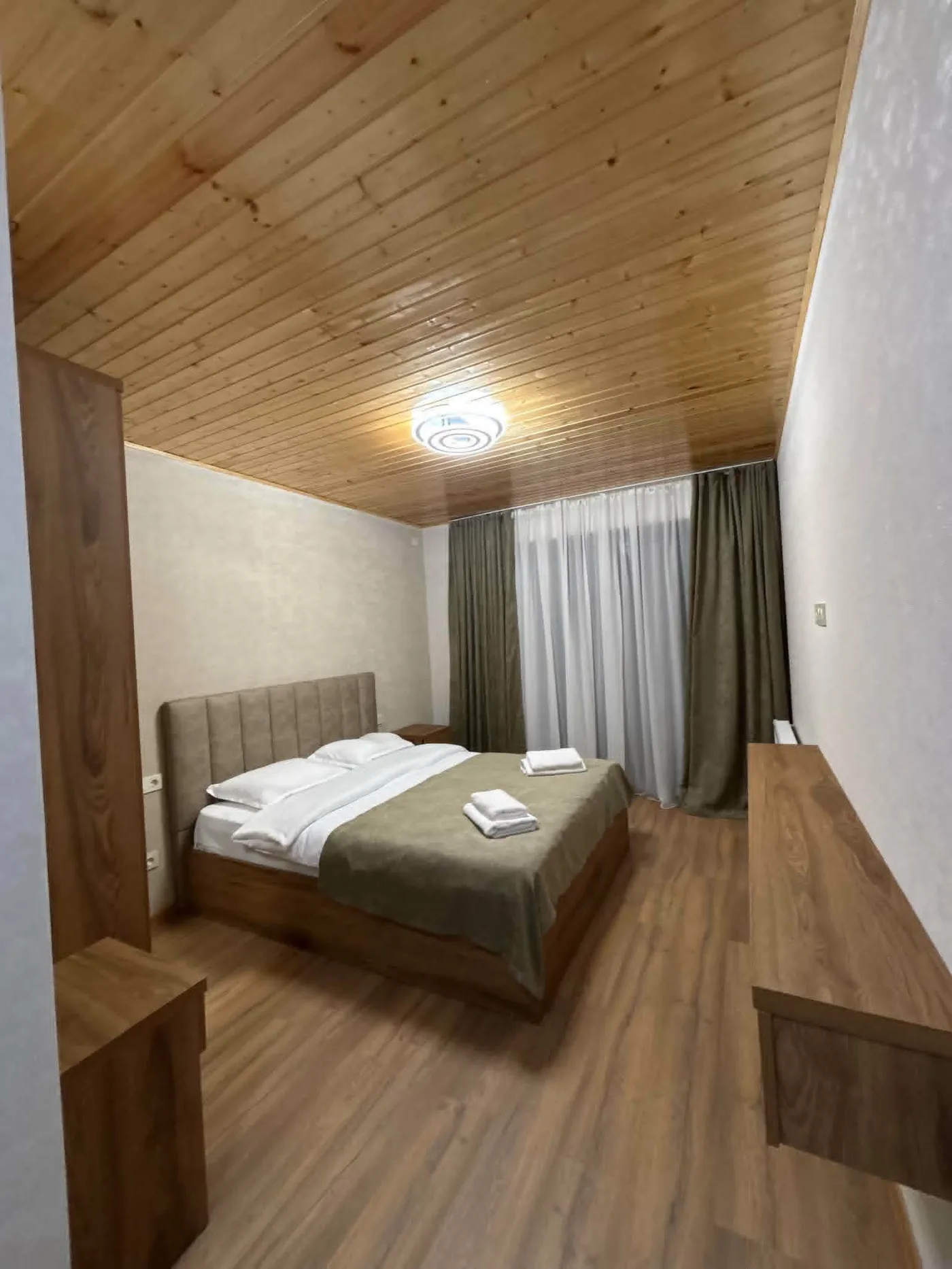 En-suite double room with a wood ceiling at a family guesthouse in Mestia, Upper Svaneti, Georgia