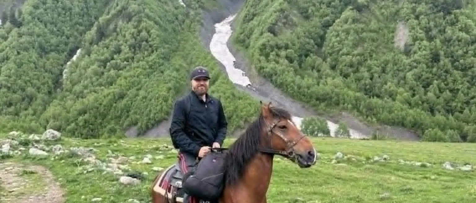 Rider on horseback above a glacial river valley in Svaneti, Georgia