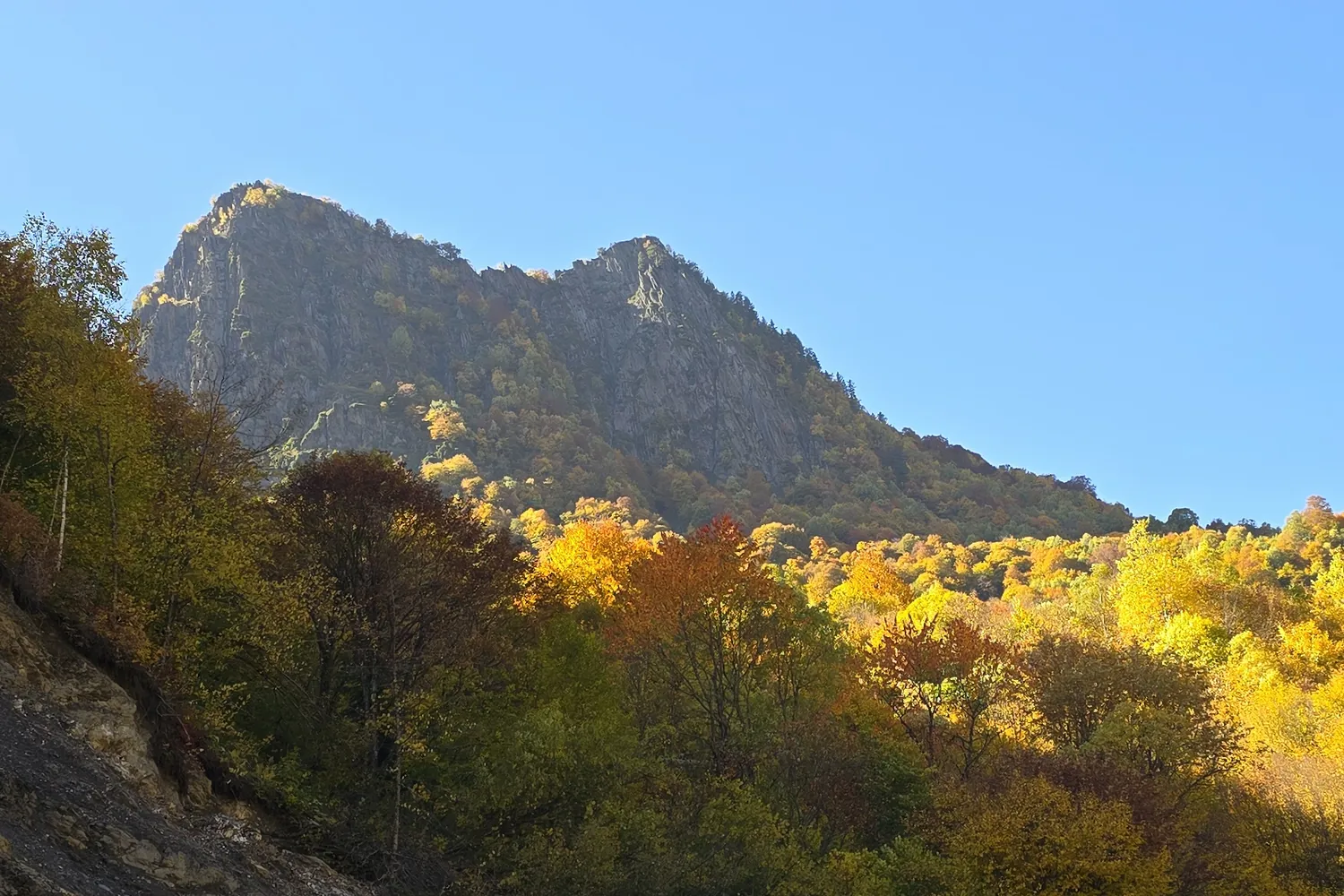 The unpaved mountain road through autumn forest towards Ushguli, Georgia