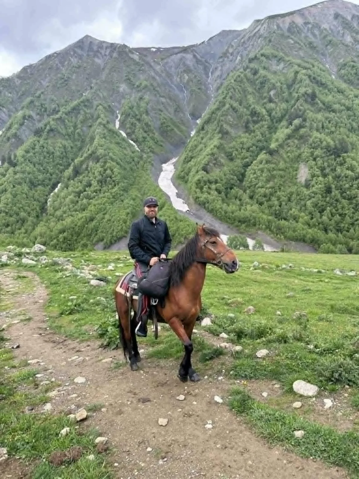 Jurijs, founder of Justvia, on horseback in the green highlands of Svaneti, Georgia