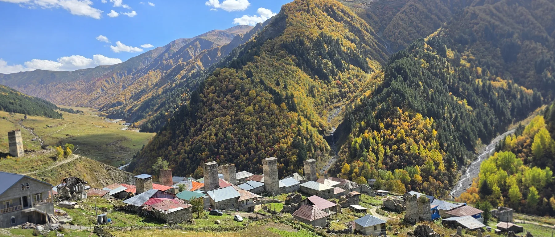 Svan village with stone towers in an autumn valley, Upper Svaneti, Georgia
