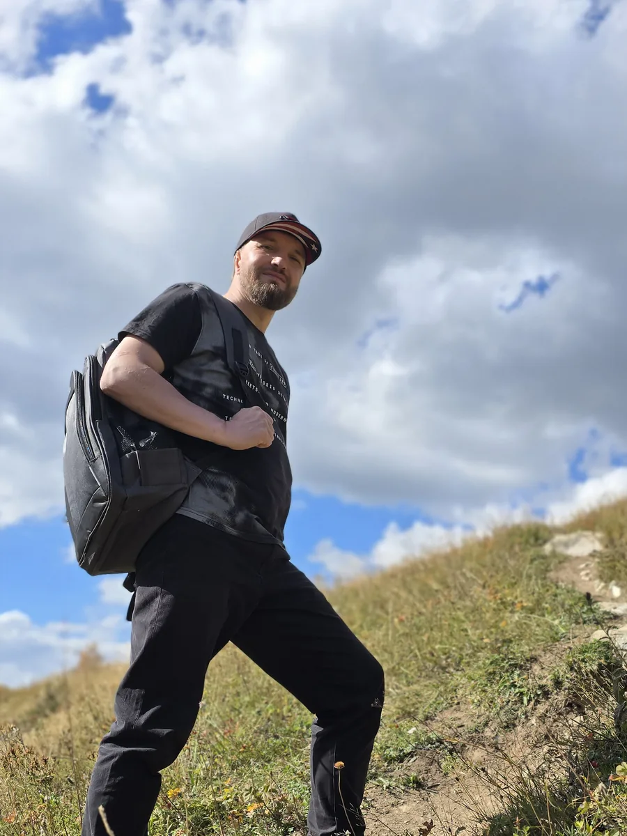 Walker with a small day pack on an autumn hillside path in Upper Svaneti, Georgia
