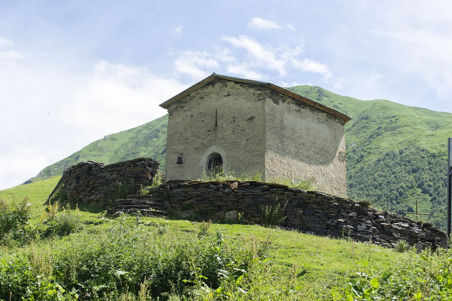 Stone church of St George, known as Jgrag, on a green hillside in Zhibiani, Ushguli, Upper Svaneti, Georgia