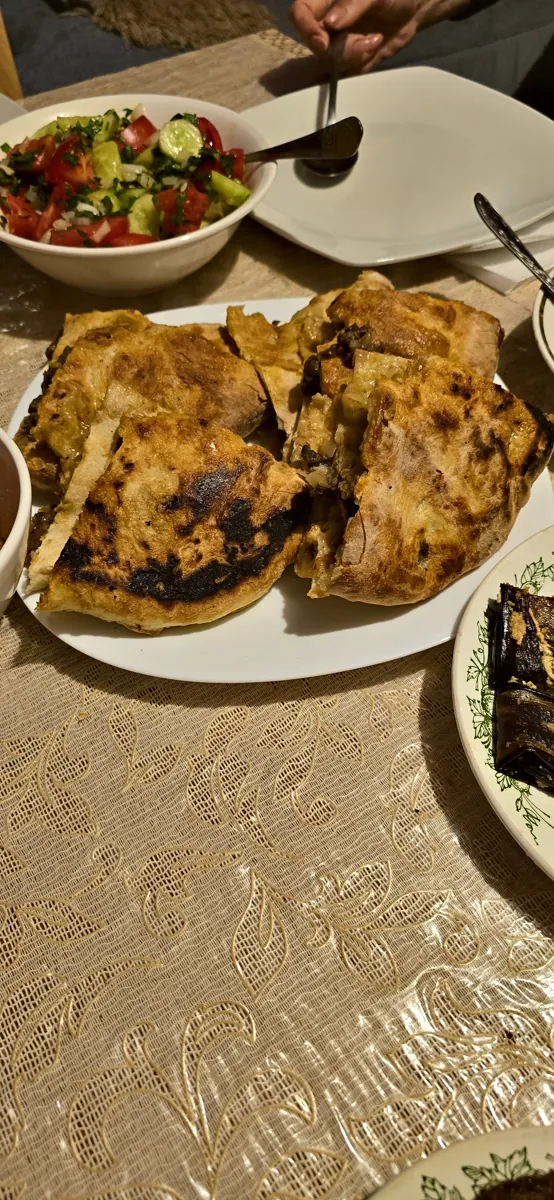 A guesthouse dinner table with khachapuri and salad, Georgia