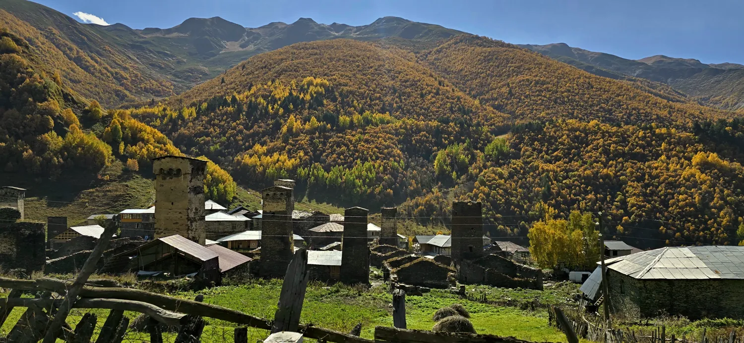 Svan towers below autumn forest in Upper Svaneti, Georgia