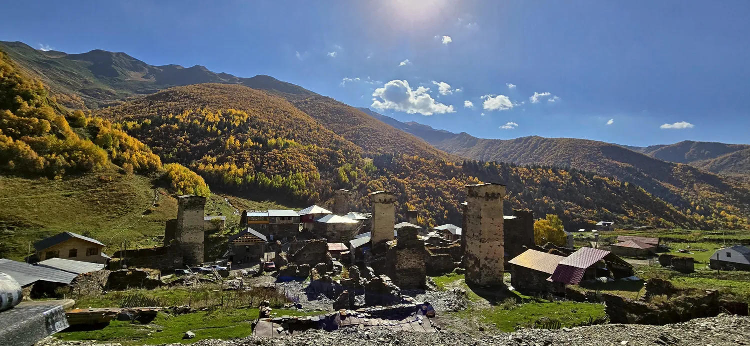 Svan towers in Ushguli below autumn hills, Upper Svaneti, Georgia