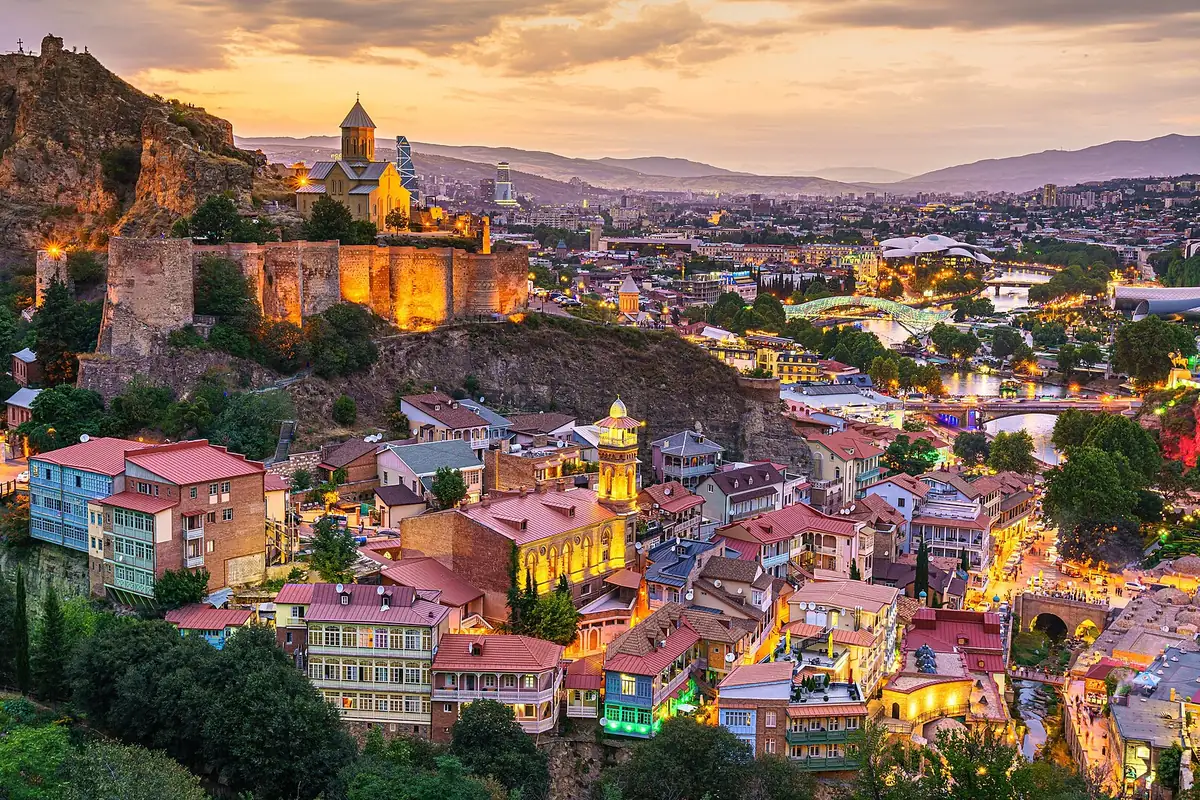 Narikala fortress lit up above the sulphur bath quarter of Abanotubani and the old town of Tbilisi at dusk, Georgia