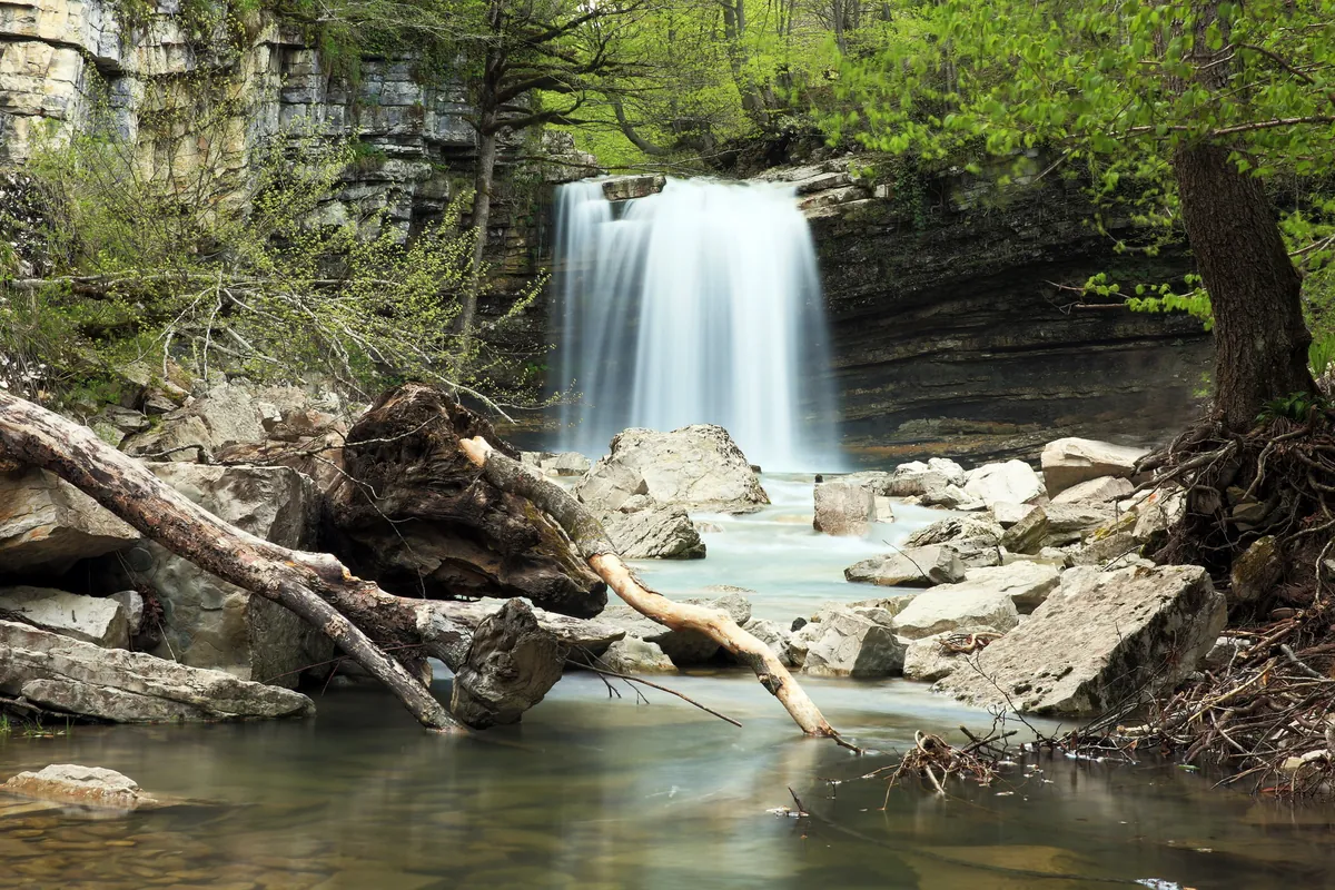 The Kinchkha waterfall falling into a pool in a wooded gorge, Imereti, Georgia